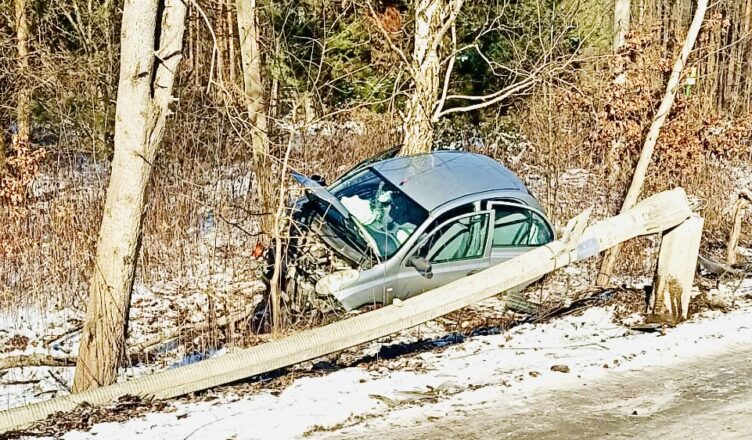 Ścięta betonowa latarnia i rozbity samochód w rowie