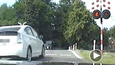 Wjechał na przejazd kolejowy pomimo czerwonego światła [wideo]. Nie wiedział, że omija policyjny radiowóz.