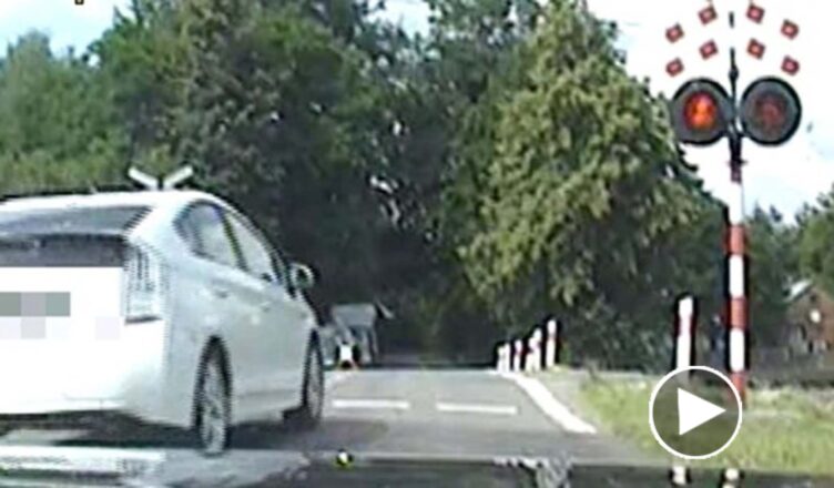 Wjechał na przejazd kolejowy pomimo czerwonego światła [wideo]. Nie wiedział, że omija policyjny radiowóz.